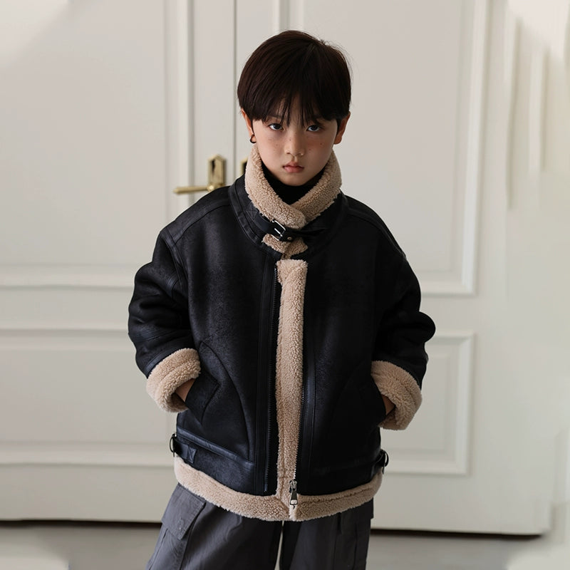 Child wearing a black jacket with beige lining in a neutral setting