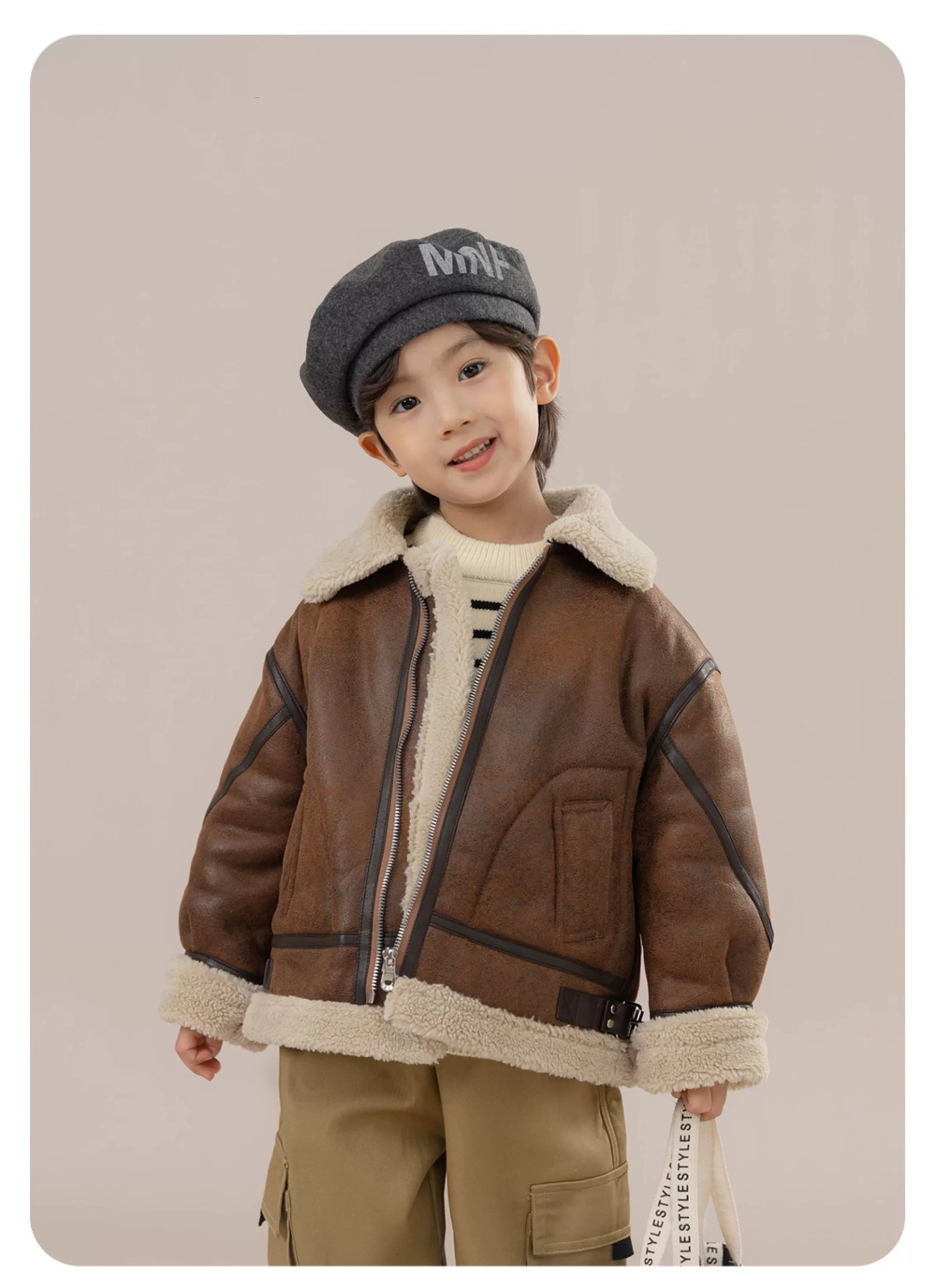 Child wearing a brown shearling jacket and gray cap with 'Floeli' logo on a beige background.