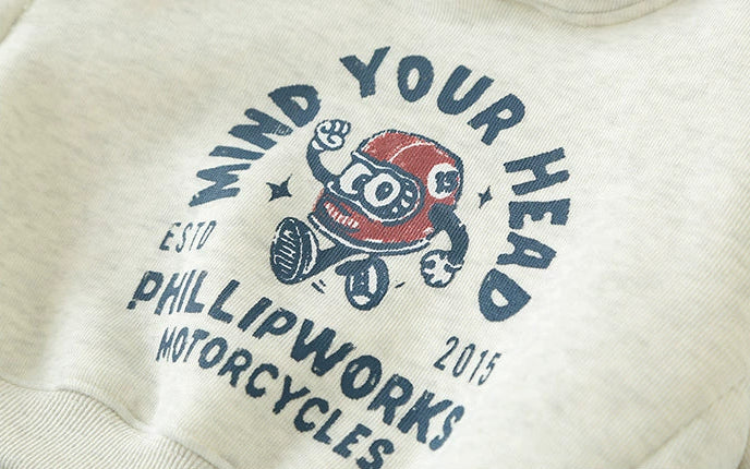 White sweatshirt with cartoon character and text design on a light gray background