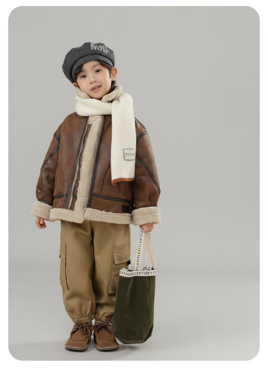 Child wearing a brown jacket with shearling lining, holding a green bag, on a beige background.