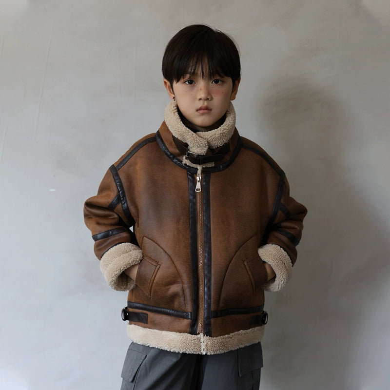 Child wearing a brown leather jacket with shearling lining against a plain background