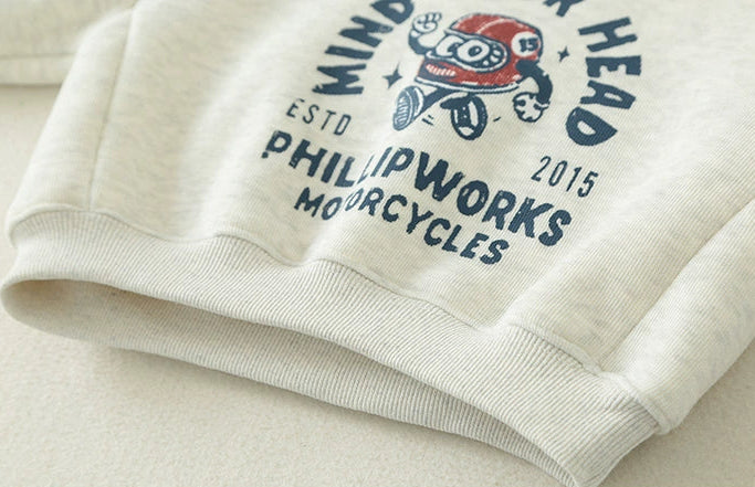 Close-up of a white garment with text and graphics, featuring 'PHILIP WORKS MOTORCYCLES' branding.