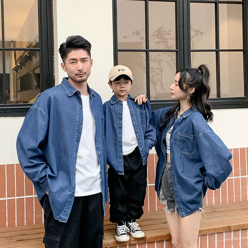 Three people wearing matching denim outfits standing outdoors.
