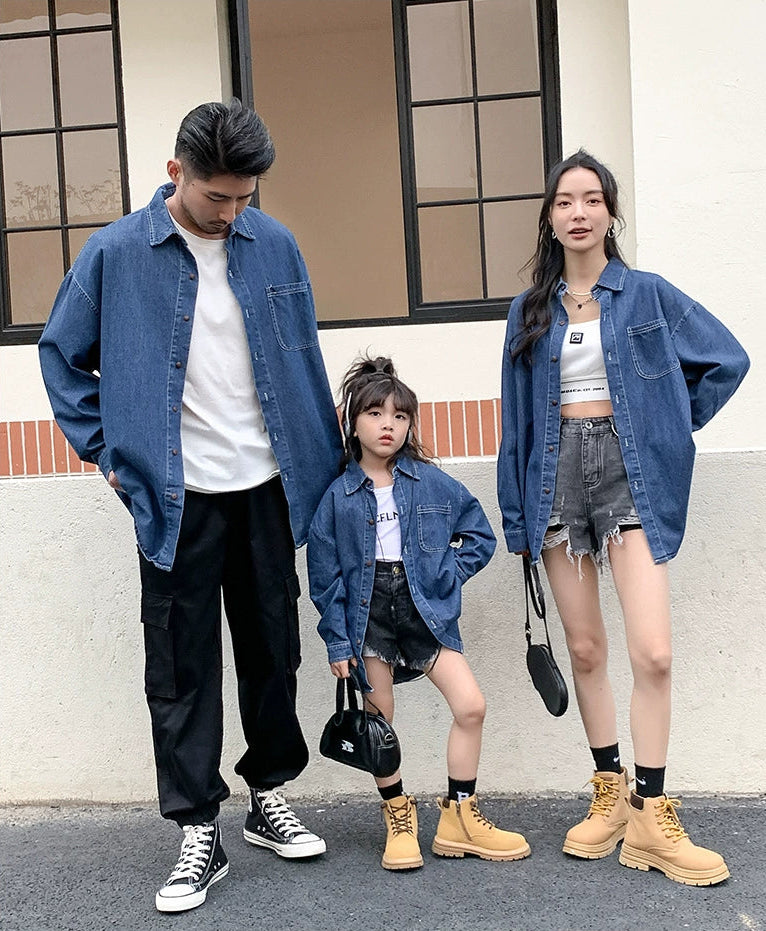 Family of three wearing matching denim outfits standing outdoors.