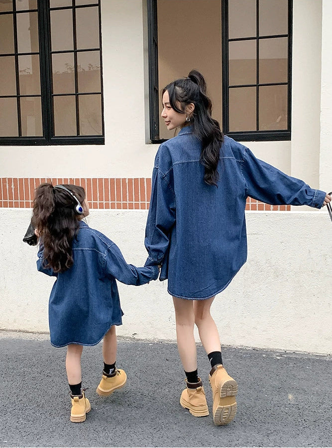 Two people wearing matching blue denim outfits walking together on a street.