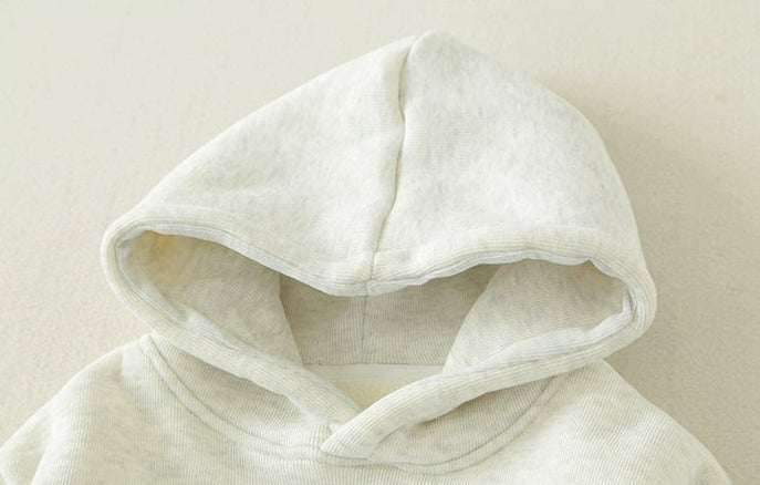 Close-up of a white hoodie with text on a beige background