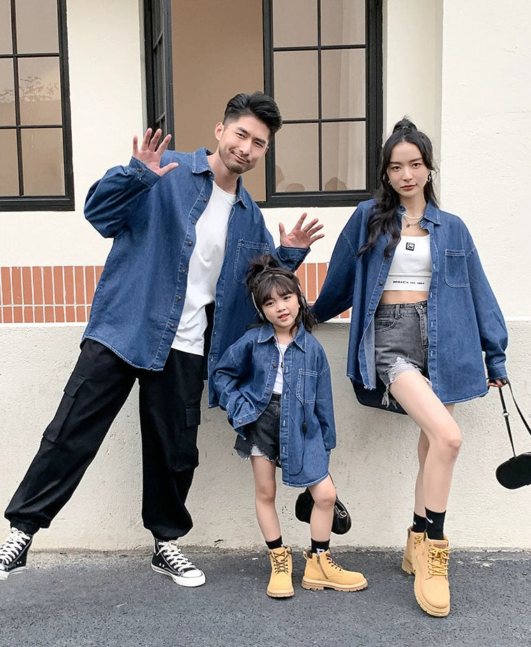 Family of three posing outdoors against a white wall with text overlay.