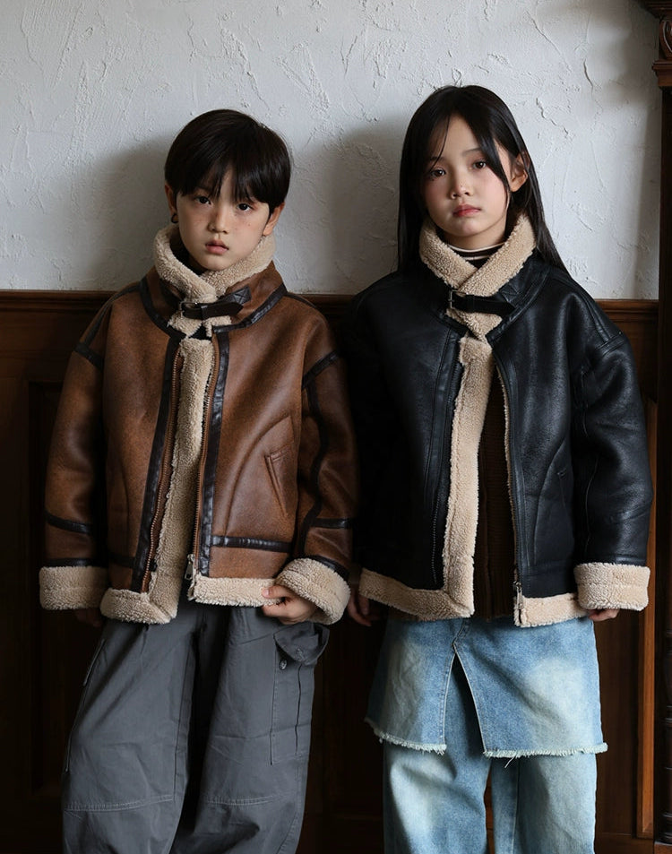 Two children wearing shearling-lined jackets against a neutral background